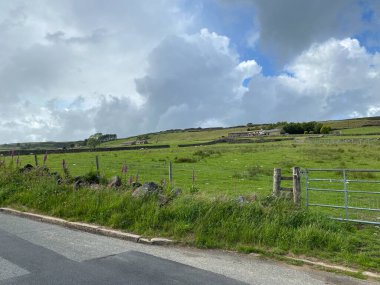 Roadside view of farm houses and fields on the road to Stanbury, Bradford, UK