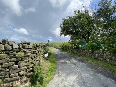 Country road, leading to a farm, high above Cowling, Keighley, UK
