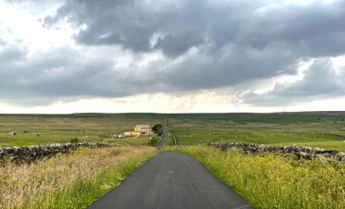 Yüksek tepelerde, kuru taş duvarlar, ağır bulutlar ve Riddlesden, İngiltere yakınlarında bir çiftlik.