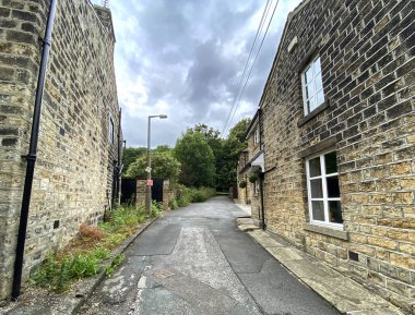 Yukarı bakıyorum, Pullan Lane, taş kulübeleriyle, ve yaşlı ağaçlarıyla, Esholt, İngiltere 'de bulutlu bir günde.