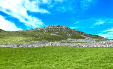 Manzara, tarlalar, kuru taş duvarlar ve dağcılar, Malham, Skipton, İngiltere yakınlarındaki tepenin zirvesinde.