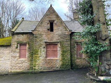 Eski ağaçları ve bulutlu gökyüzü olan terkedilmiş Viktorya Locası, İngiltere 'nin Bradford kentindeki sanayi bölgesinde.
