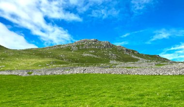 Ufukta dört dağcı, Derek Oldfield 'ın yazdığı Malham, UK Derek Oldfield yakınlarındaki Yorkshire Dales' de kireçtaşı zirvelerine tırmanıyor.