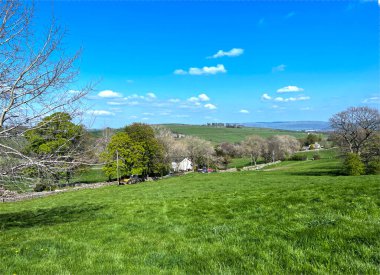 Geniş kırsal alan, eğimli yeşil alanlar, çiftlikler ve Lothersdale, İngiltere yakınlarındaki uzak tepeler.