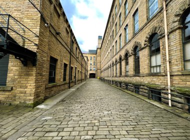 Stone Cobbled Caddesi, iki eski Viktorya dönemi değirmeni arasında Saltaire, Yorkshire, İngiltere 'nin göbeğinde.