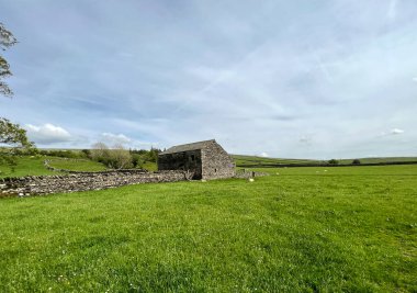Yorkshire Dales manzarası, geniş tarlaları, eski bir taş ahırı ve yakın üzerinde ağır bulutlar, Dovecote, Horton, RibBlesdale, İngiltere 