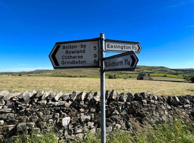 Grindleton, Clitheroe, İngiltere yakınlarındaki tepelerde, kuru bir taş duvarın yanında yol tabelası var.