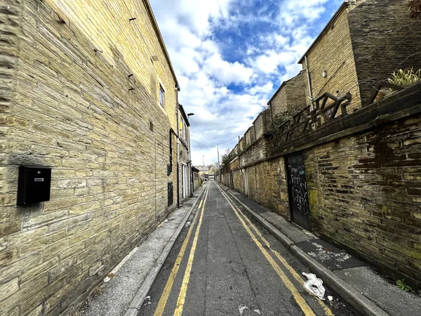 Back street, with Victorian stone buildings next to, Great Horton Road, on a cloudy day in, Bradford, UK