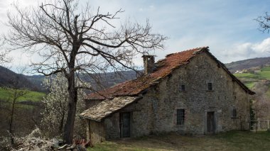 Terk edilmiş bir İtalyan köyü evi tepede.