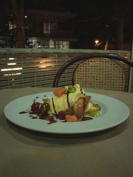 Puff pastry with cream and fruits covered with hot chocolate