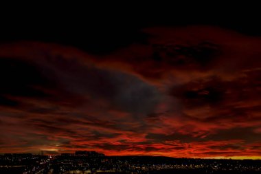 Şehrin üzerinde koyu kırmızı gün doğumu