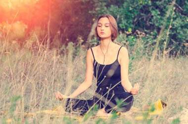 Güzel bir kız sokakta yoga ile meşgul. Rahatlatıcı egzersizler, sağlıklı yaşam tarzı konsepti.