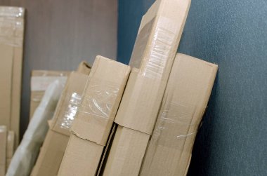 Marketin deposunun duvarının yanında duran karton paketler. Paketleme malzemesi.