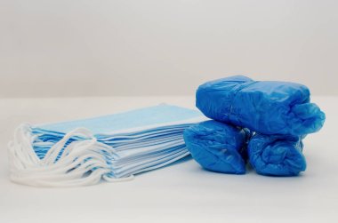 Tıbbi maskeler ve ayakkabı kılıfları. Tıbbi sağlık koruması. COVID-19 salgını. Yakın çekim, seçici odaklanma.