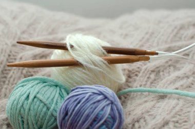 Sıcak, sade bir ortam. Kadın örgü hobisi. Sıcak renklerde iplik. Bir kadın süveteri örme sürecinin başlangıcı.