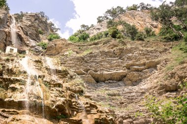 Beautiful summer landscape of a stone mountain with a waterfall.