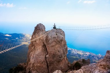 View of rock with a rope bridge on the Mount Ai-Petri in Crimea. Ai-Petri is one of the highest mountains in Crimea and tourist attraction. Hanging bridge on Ai-Petri over the abyss.