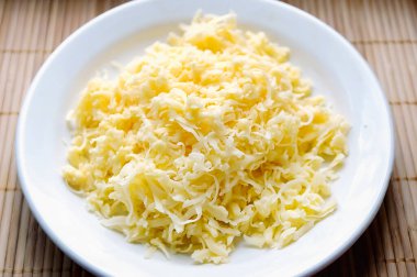 Beyaz tabakta rendelenmiş peynir