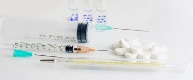 Beyaz arka planda şırınga ve ilaçlar, panoramik fotoğraf.