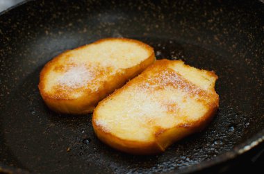 Kızarmış beyaz ekmek üzerine şeker serpiştirilmiş.