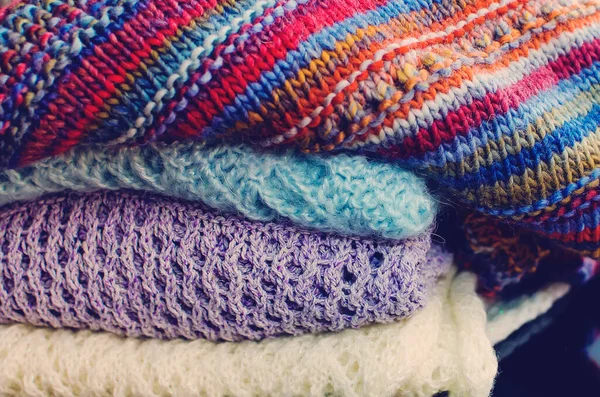 Stack of women\'s knit cardigans and sweaters. Close-up, selective focus.