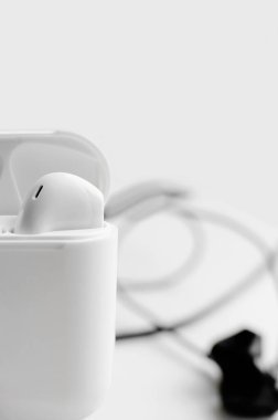 Kablosuz kulaklıklar beyaz arka planda parlak, beyaz plastik bir kutuda. Yakın plan, dikey fotoğraf.