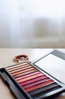 Mat göz farı çok renkli tonlar paleti masanın üzerinde yatıyor. Yakın plan, seçici odaklanma. Dikey fotoğraf.