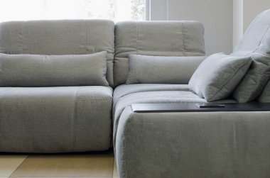 Modern oturma odasında yastıkları olan gri köşeli kanepe.