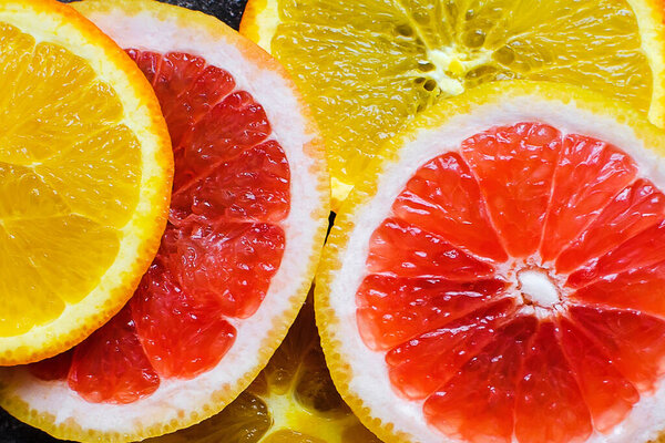 Красочные цитрусовые фрукты - апельсин, грейпфрут - ломтики фона. Концепция здорового питания, натуральные витамины, диета, вегетарианское питание.