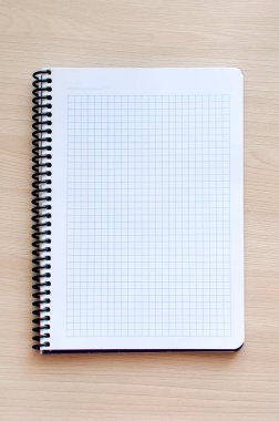 Tahta bir masanın üzerindeki sarmal not defteri, dikey fotoğraf. Metin ve metin boşluğu için yer.