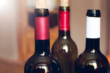 Masada üç şişe şarap var. Yakın çekim, seçici odaklanma.