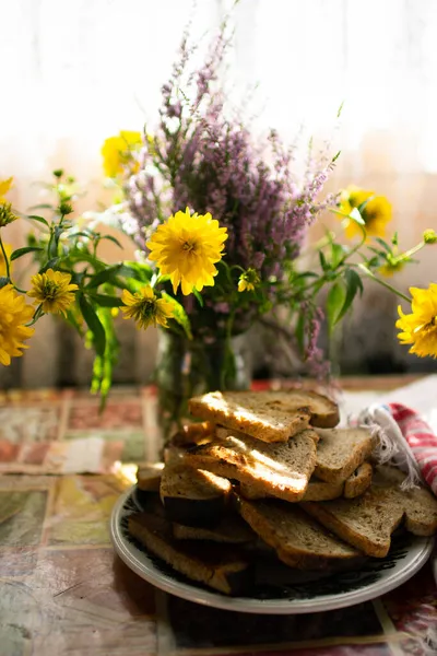 Masada kızarmış ekmek ve bir buket yabani çiçek.