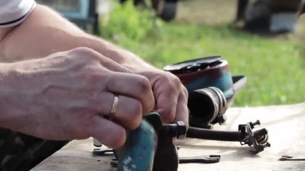 A man repairs a blue spare part — Vídeo de Stock