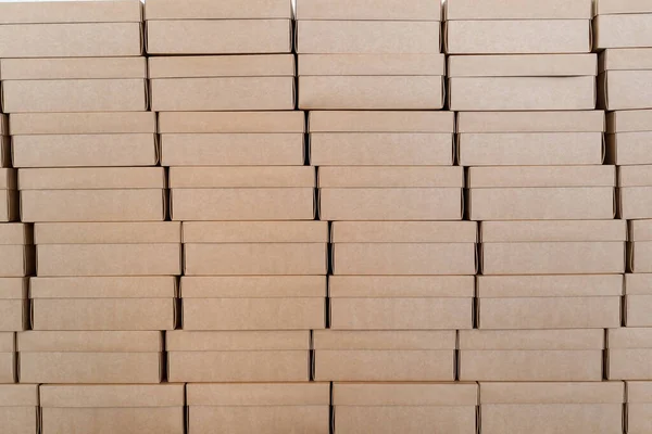 Pared hecha de cajas de cartón cerradas apiladas en patrón — Foto de Stock