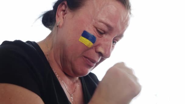 Украинка с флагом Украины на лице, страдающая и молящаяся о мире во время военного конфликта между Россией и Украиной, вторжение России на Украину — стоковое видео
