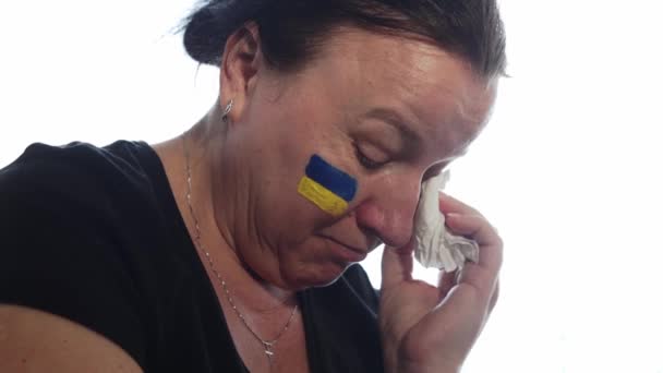 Ukrajinská žena s vlajkou Ukrajiny na tváři trpí a modlí se za mír během válečného konfliktu mezi Ruskem a Ukrajinou, invaze Ruska na Ukrajině — Stock video