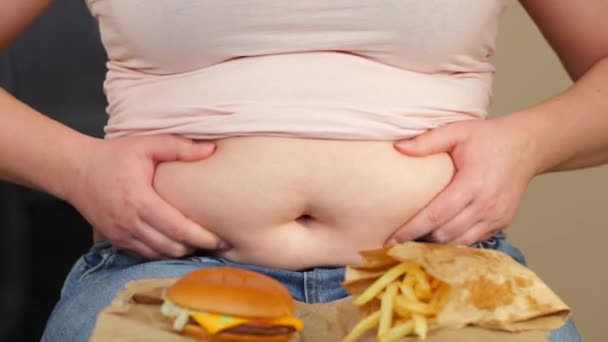 Fiatal túlsúlyos vagy plusz méretű nő zsíros, nagy has és egészségtelen élelmiszer hamburger és sült chips, élet az emberek xl méret, vastag és kövér koncepció — Stock videók