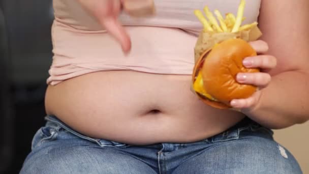 Mladá nadváha nebo plus velikost žena s tlusté, velké břicho a nezdravé jídlo hamburger a smažené hranolky, život lidí xl velikost, tlusté a tučné koncepce — Stock video