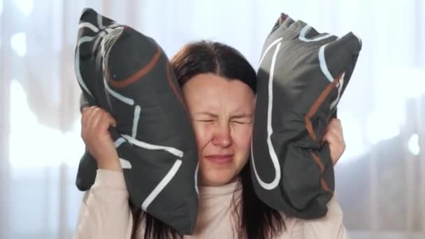 Junge Frau mit Tinnitus, die ihre Ohren mit einem Kissen bedeckt, Schlaflosigkeit oder Stress-Konzept, kranke Frau mit Ohrenschmerzen, die ihren schmerzenden Kopf berührt, Gesundheitsversorgung — Stockvideo