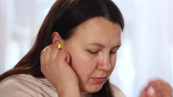 Jeune femme souffrant d'acouphènes maladie, mettre sur ses bouchons d'oreille, insomnie ou concept de stress, femme malade ayant une douleur à l'oreille toucher sa tête douloureuse, soins de santé — Video