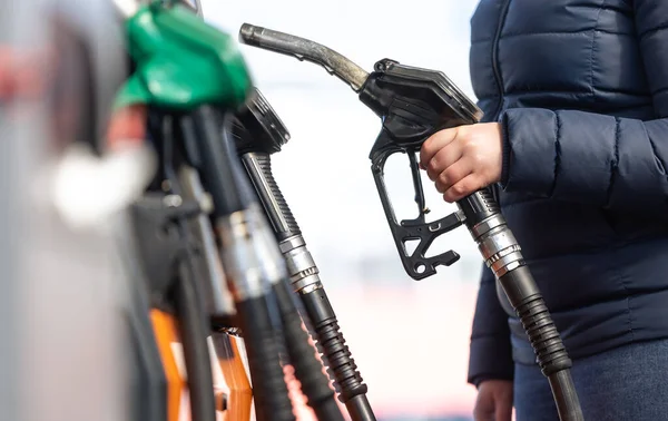 Высокие цены на бензин и дизельное топливо на АЗС, молодая женщина заправляющая автомобиль, концепция экономического кризиса — стоковое фото