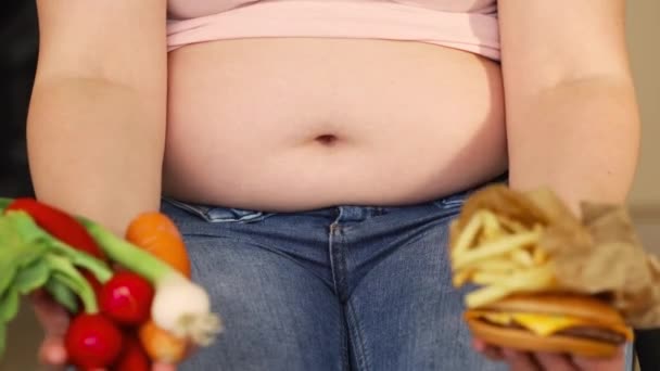 肥胖、大肚子、健康食品、汉堡包、油炸土豆片和健康蔬菜的年轻超重或体形更大些的女人，一个人的一生xl尺码，粗脂肪的概念 — 图库视频影像