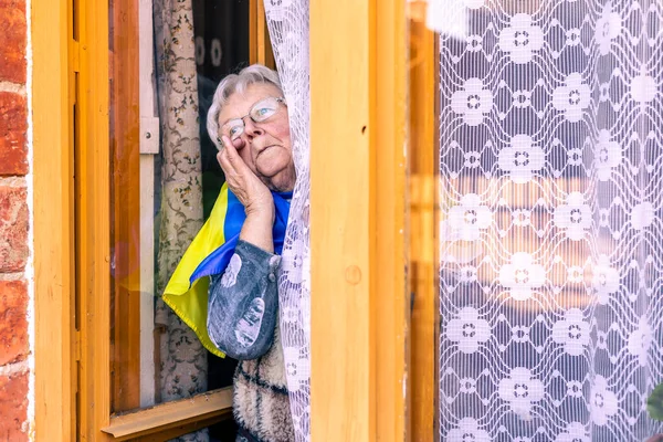 Mulher sênior com a Ucrânia a bandeira chorando, sofrendo e rezando a paz durante o conflito de guerra entre a Rússia e a Ucrânia, invasão da Rússia na Ucrânia, orar pela Ucrânia — Fotografia de Stock