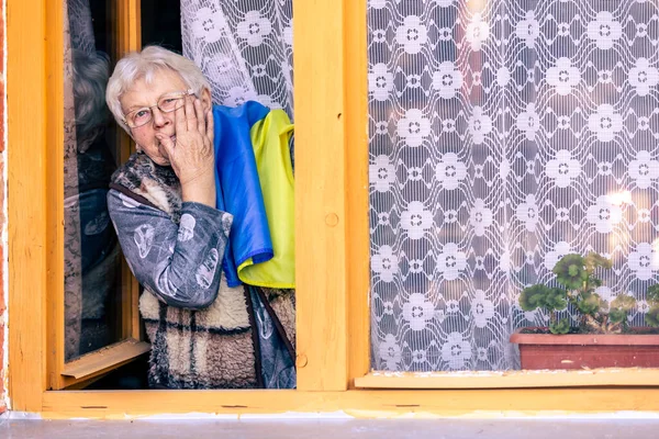 Mujer mayor con bandera de Ucrania llorando, sufriendo y rezando por la paz durante el conflicto de guerra entre Rusia y Ucrania, invasión de Rusia en Ucrania, orar por Ucrania — Foto de Stock