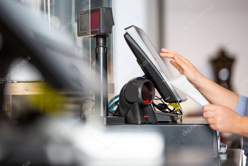 Concept of small business or sevice, woman or saleswoman in apron at counter with a cashbox working at clothes shop, touchscreen POS, finance concept, business