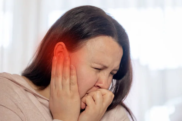 Mujer joven que sufre de enfermedad de tinnitus, insomnio o concepto de estrés, mujer enferma que tiene dolor de oído tocando su cabeza dolorosa, concepto de salud — Foto de Stock