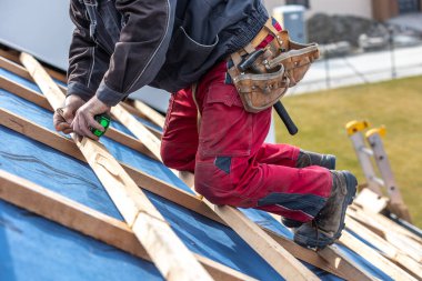 Zanaatkar veya inşaat işçisi yeni bir çatı, çatı aletleri, yeni metalik çatı veya metal levha, bina konsepti