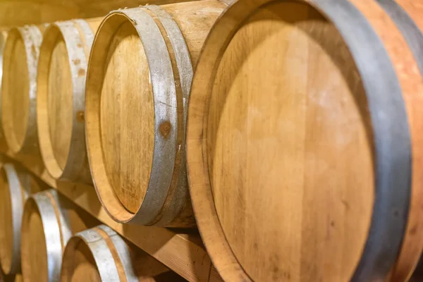 Primo piano di botti di vino in archi di vino in fila in una cantina, botti di vino impilati, concetto di vigneto — Foto Stock