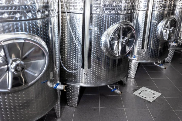 Chiusura di una fabbrica di vino con piccoli serbatoi di acciaio per lo stoccaggio e la fermentazione di arrenge di vino, concetto di bevanda alcolica — Foto Stock