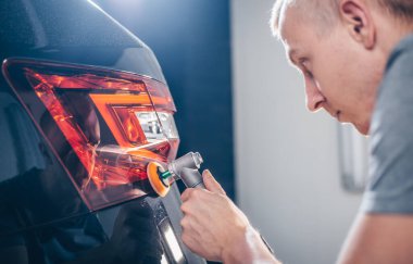 Araba temizleme - Oto tamir atölyesinde orbital parlatıcıyla el ele